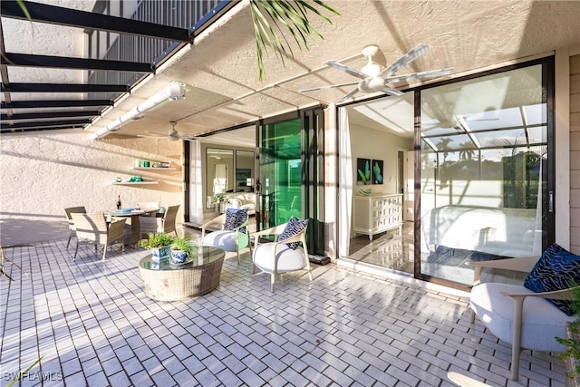 view of patio / terrace with ceiling fan and glass enclosure