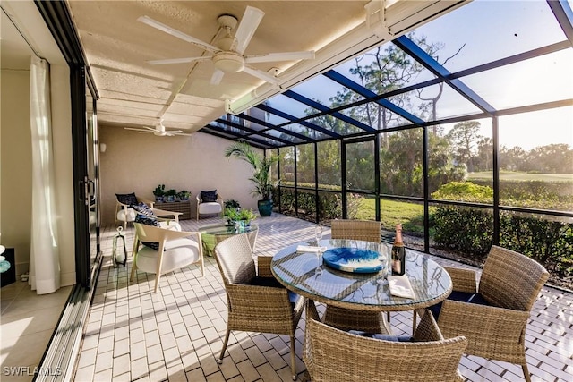 view of patio with ceiling fan and glass enclosure