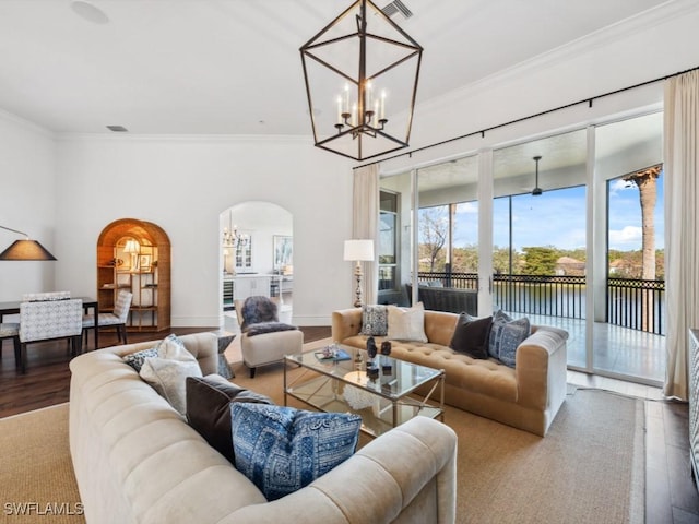 living room with hardwood / wood-style flooring, ornamental molding, and a notable chandelier