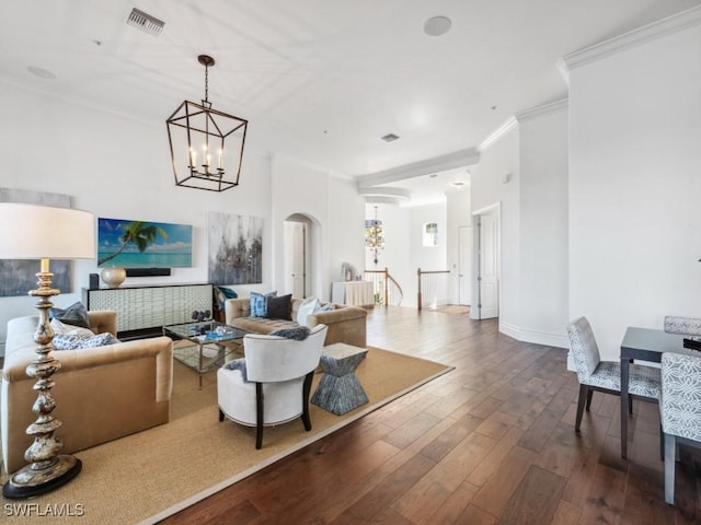 living room with crown molding, wood-type flooring, and a chandelier