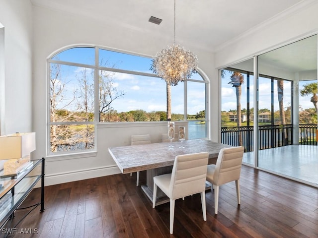 sunroom featuring a chandelier and a water view