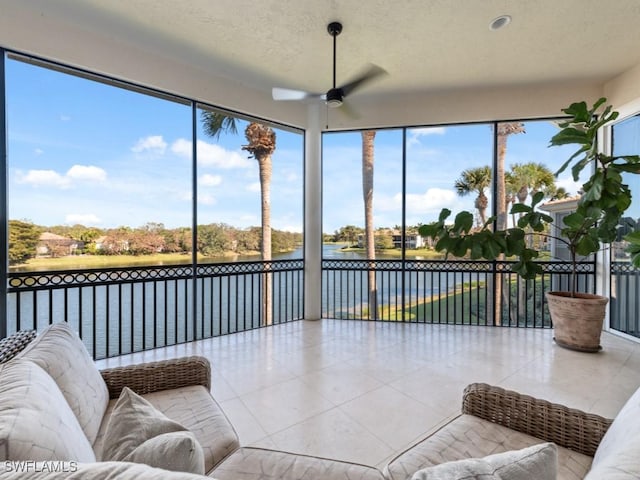 sunroom featuring a water view and ceiling fan