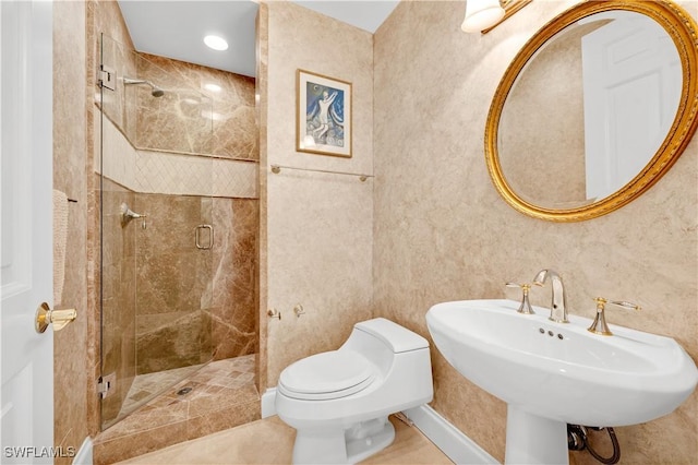 bathroom with tile patterned floors, toilet, sink, and walk in shower