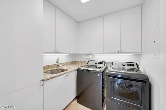 laundry room featuring cabinets, washing machine and dryer, and sink