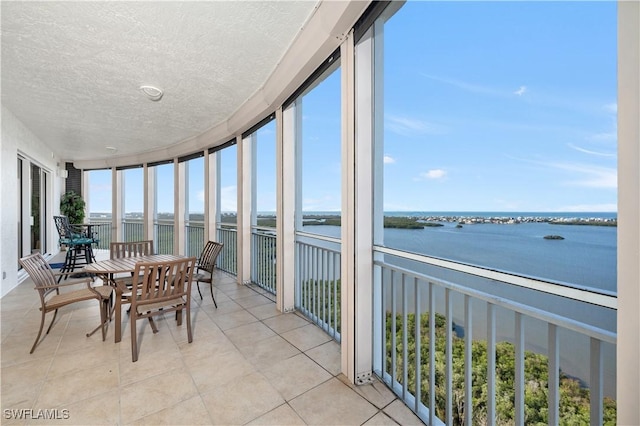 sunroom featuring a wealth of natural light and a water view