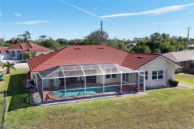 rear view of property with a lanai, a yard, and a patio