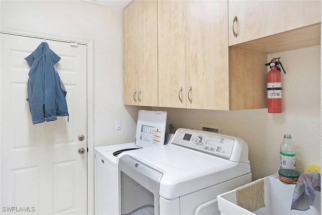 clothes washing area featuring cabinets, separate washer and dryer, and sink