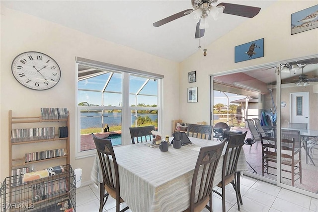 dining space with light tile patterned floors, a water view, ceiling fan, and lofted ceiling