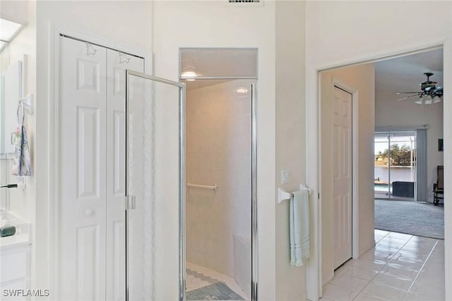 bathroom with tile patterned floors, ceiling fan, and a shower with shower door