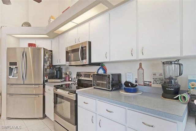 kitchen with white cabinetry, light tile patterned flooring, and stainless steel appliances