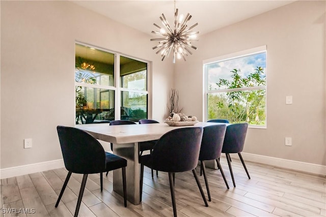 dining area with light hardwood / wood-style floors and an inviting chandelier