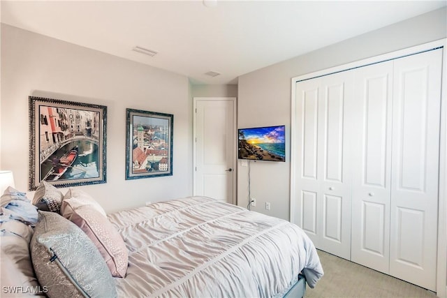 bedroom featuring light colored carpet and a closet