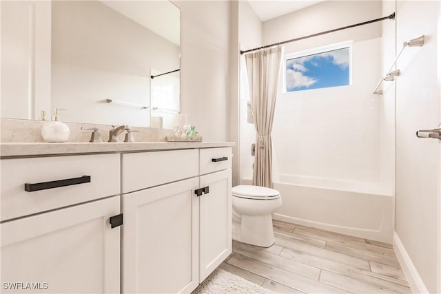 full bathroom with shower / bath combo, vanity, hardwood / wood-style flooring, and toilet