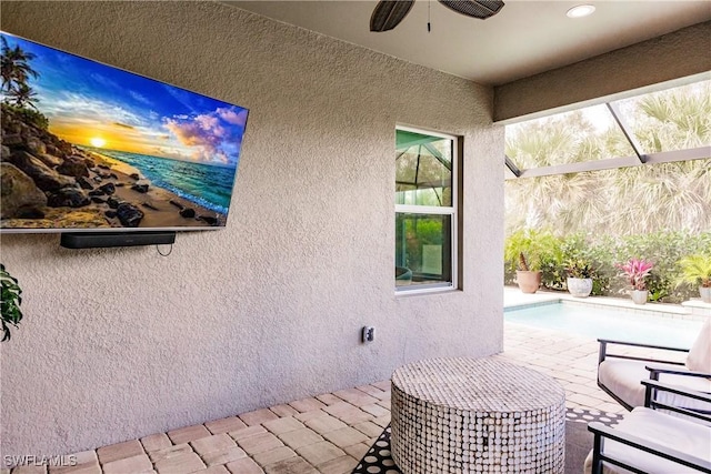 view of patio with ceiling fan and glass enclosure