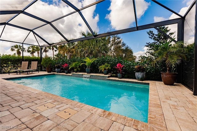 view of swimming pool featuring pool water feature, a patio, and a lanai