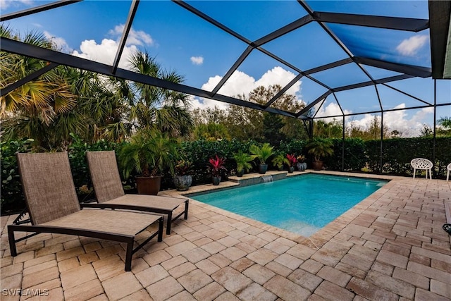 view of pool featuring glass enclosure and a patio