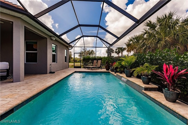 view of pool with a lanai, pool water feature, and a patio