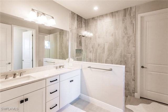 bathroom featuring a tile shower, tile patterned flooring, and vanity