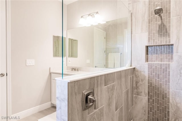 bathroom featuring vanity and tiled shower