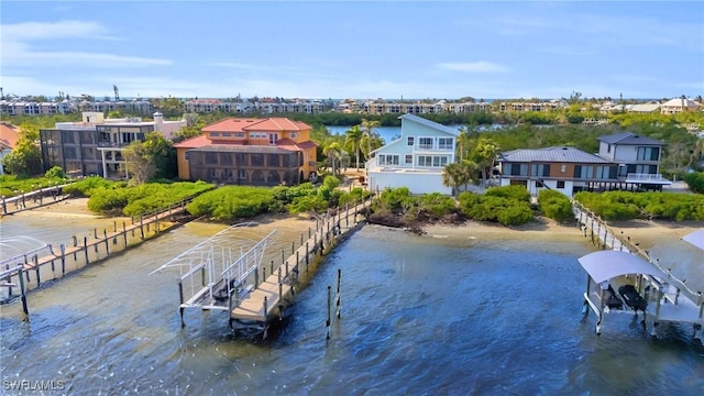 dock area featuring a water view, boat lift, and a residential view