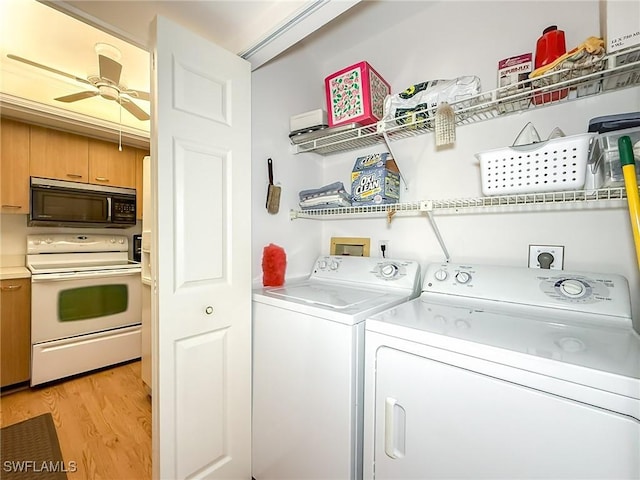 laundry area featuring ceiling fan, washing machine and dryer, and light hardwood / wood-style flooring