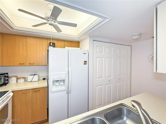 kitchen with a tray ceiling, ceiling fan, white appliances, and ornamental molding