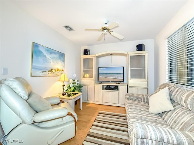 living room with light hardwood / wood-style floors and ceiling fan