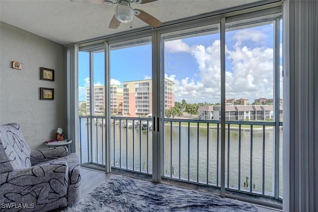 bedroom featuring multiple windows, hardwood / wood-style floors, a water view, and floor to ceiling windows