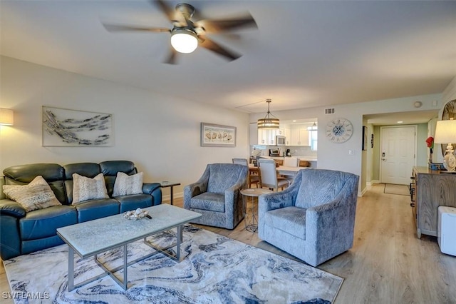 living room with ceiling fan and light hardwood / wood-style floors