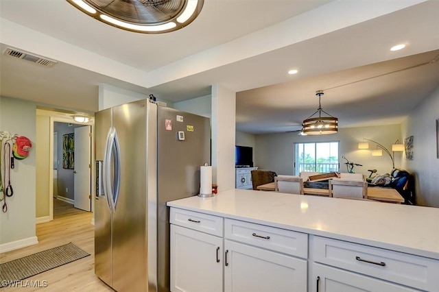 kitchen featuring white cabinets, stainless steel fridge, light hardwood / wood-style flooring, and pendant lighting