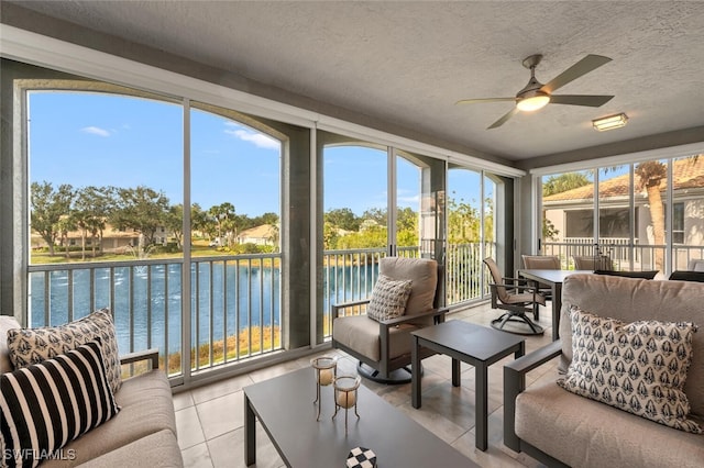 sunroom / solarium featuring a water view and ceiling fan