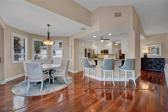 dining area featuring ceiling fan, lofted ceiling, and dark hardwood / wood-style floors