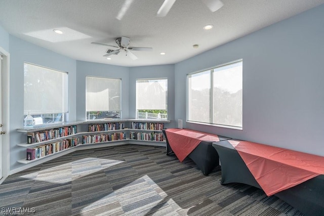 interior space with a ceiling fan, carpet, a textured ceiling, and recessed lighting