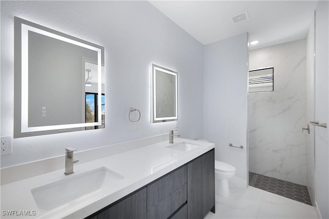 bathroom featuring tiled shower, vanity, and toilet