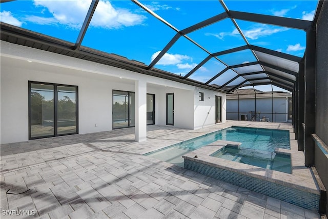 view of pool featuring an in ground hot tub, glass enclosure, and a patio area