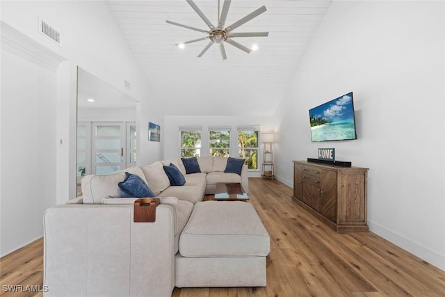 living room with light hardwood / wood-style floors, high vaulted ceiling, and ceiling fan