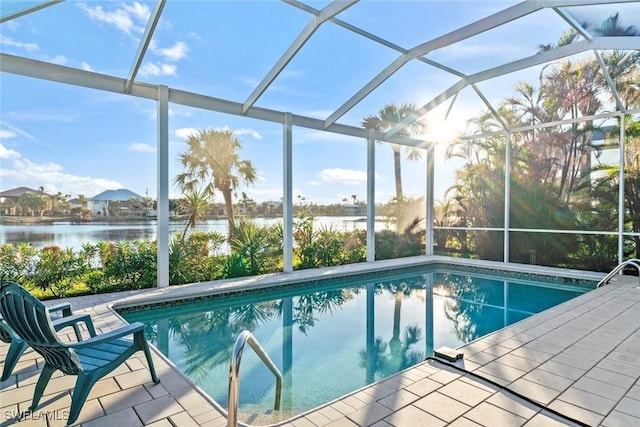 view of swimming pool with a lanai, a patio area, and a water view