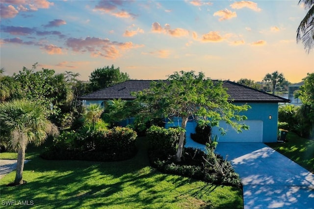 view of front of house with a garage and a yard