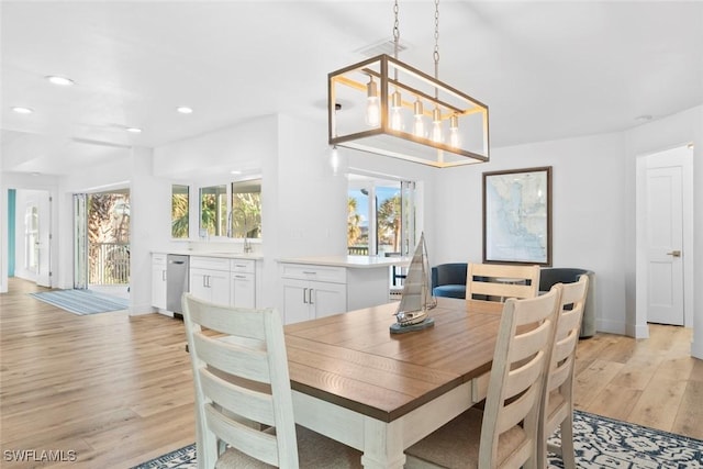 dining area featuring light hardwood / wood-style floors and an inviting chandelier