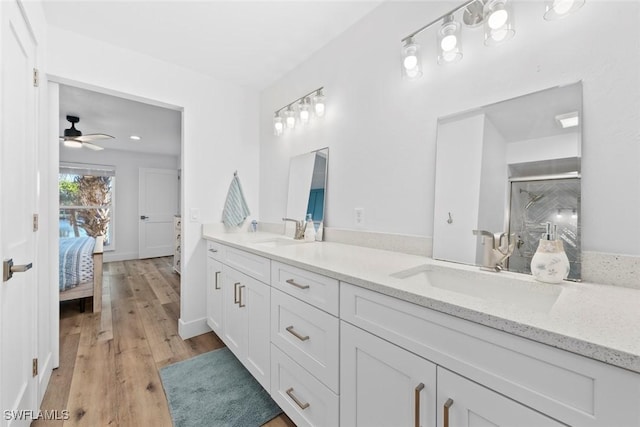 bathroom featuring hardwood / wood-style floors, vanity, a shower with door, and ceiling fan