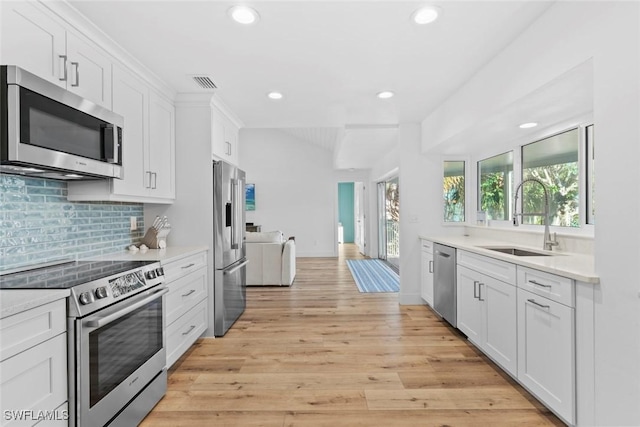 kitchen featuring sink, white cabinetry, stainless steel appliances, and light hardwood / wood-style flooring