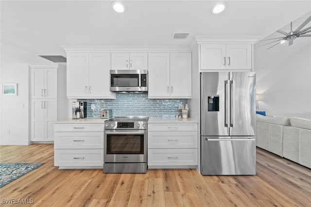 kitchen featuring decorative backsplash, light wood-type flooring, white cabinetry, and stainless steel appliances