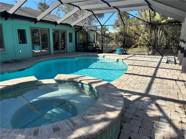 view of swimming pool featuring a lanai, a patio area, and an in ground hot tub