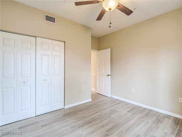 unfurnished bedroom featuring ceiling fan, light wood-type flooring, and a closet