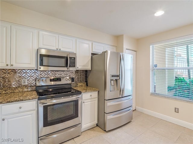 kitchen with dark stone counters, white cabinets, and stainless steel appliances