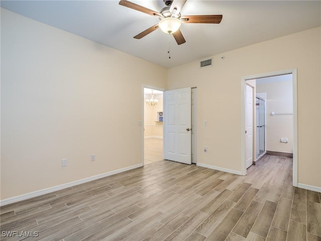 unfurnished bedroom with ceiling fan with notable chandelier and light wood-type flooring