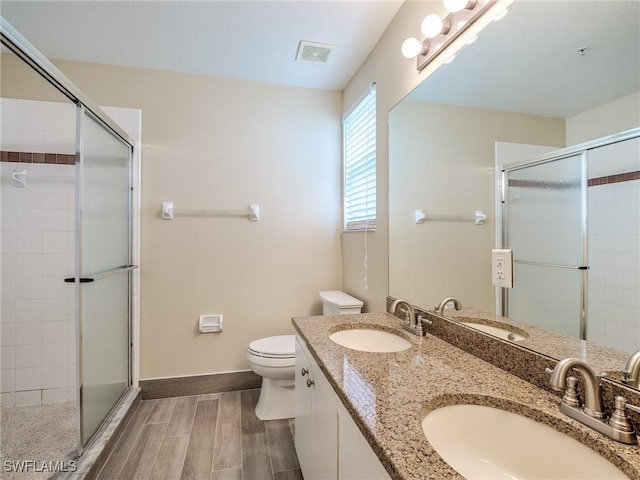 bathroom featuring vanity, toilet, and a shower with door