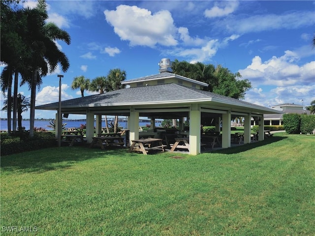 view of property's community with a gazebo, a lawn, and a water view