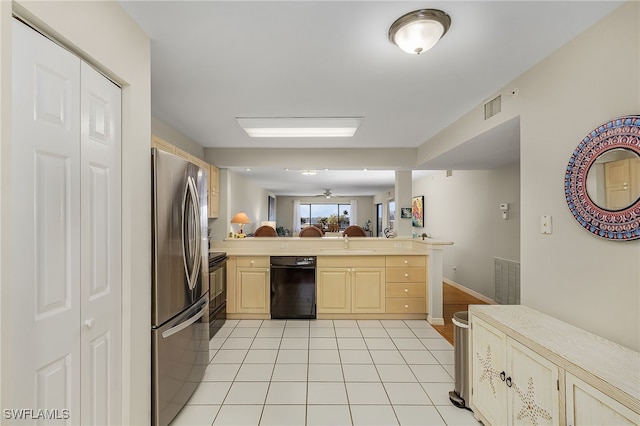 kitchen featuring black appliances, sink, light brown cabinetry, light tile patterned flooring, and kitchen peninsula