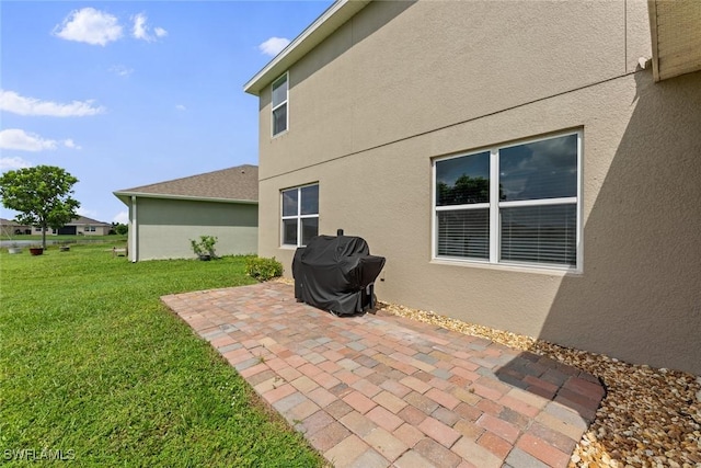 rear view of property featuring a yard and a patio